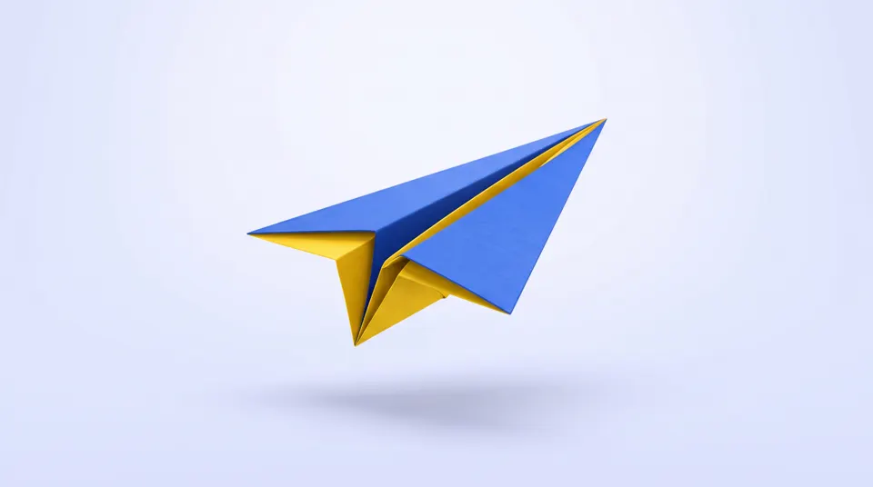 A blue and yellow origami paper plane in flight