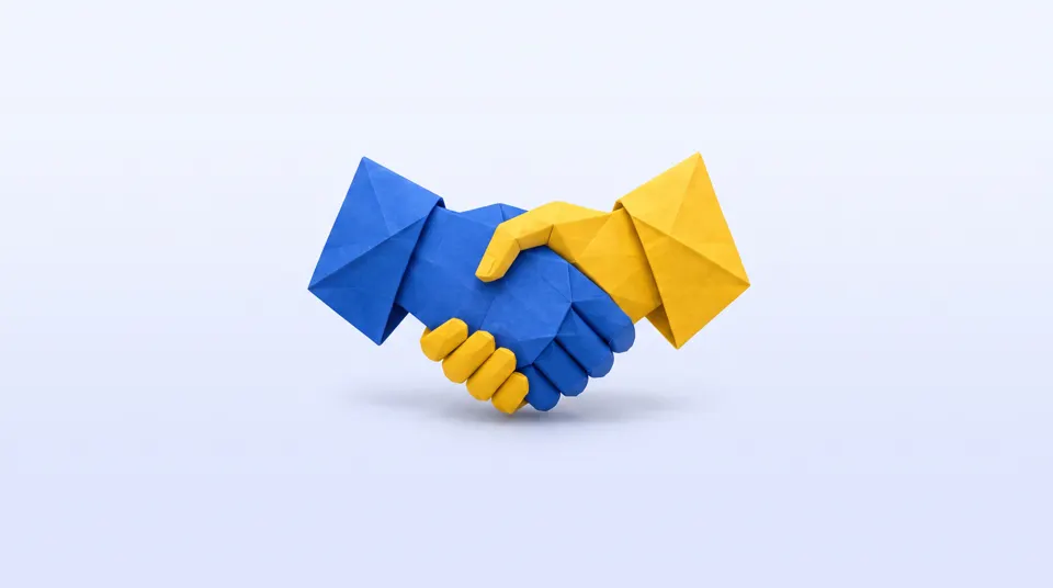 Two origami paper hands, one blue and one yellow, shaking hands